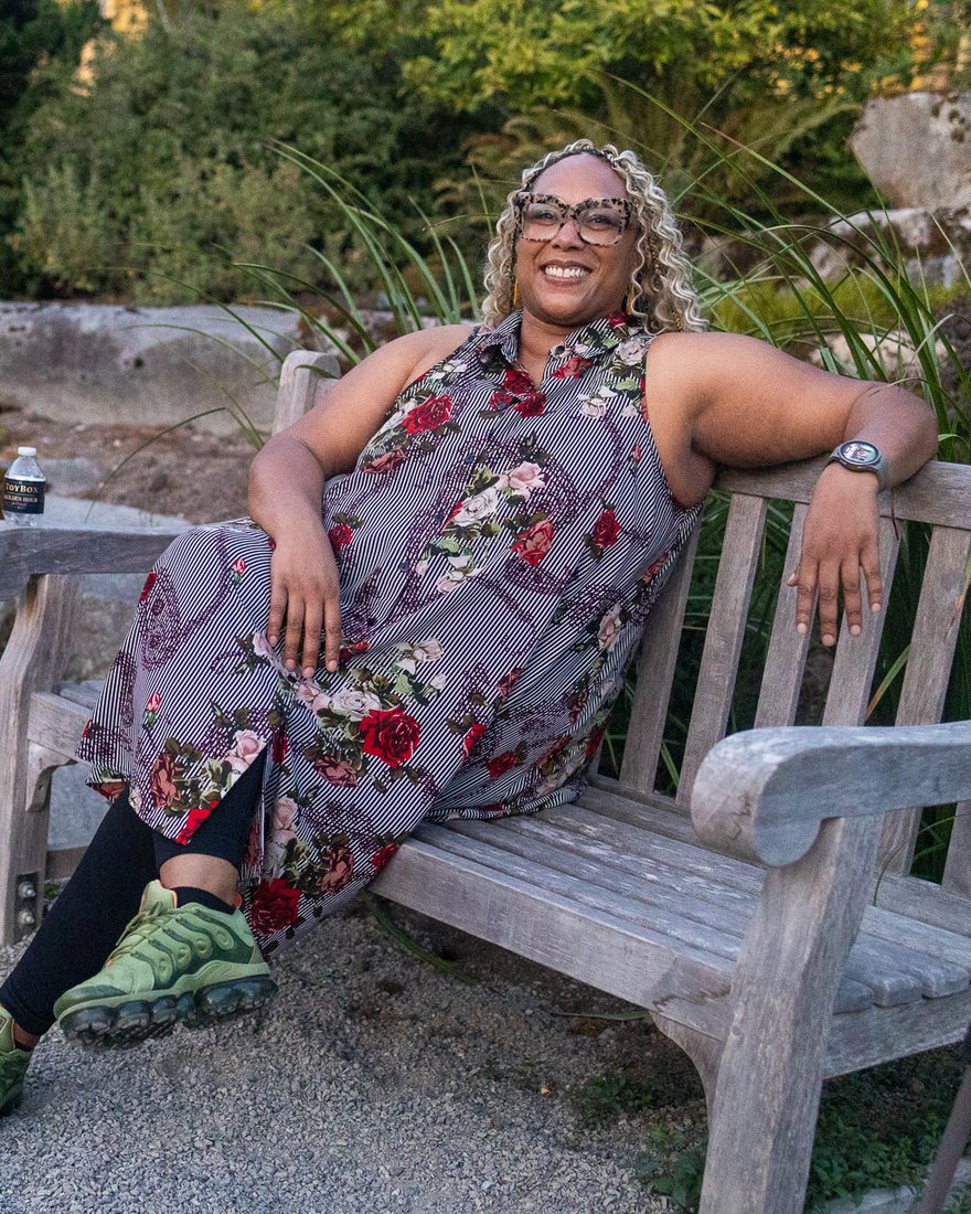 Katoya Palmer seated on a garden bench at Golden Hour Unboxed